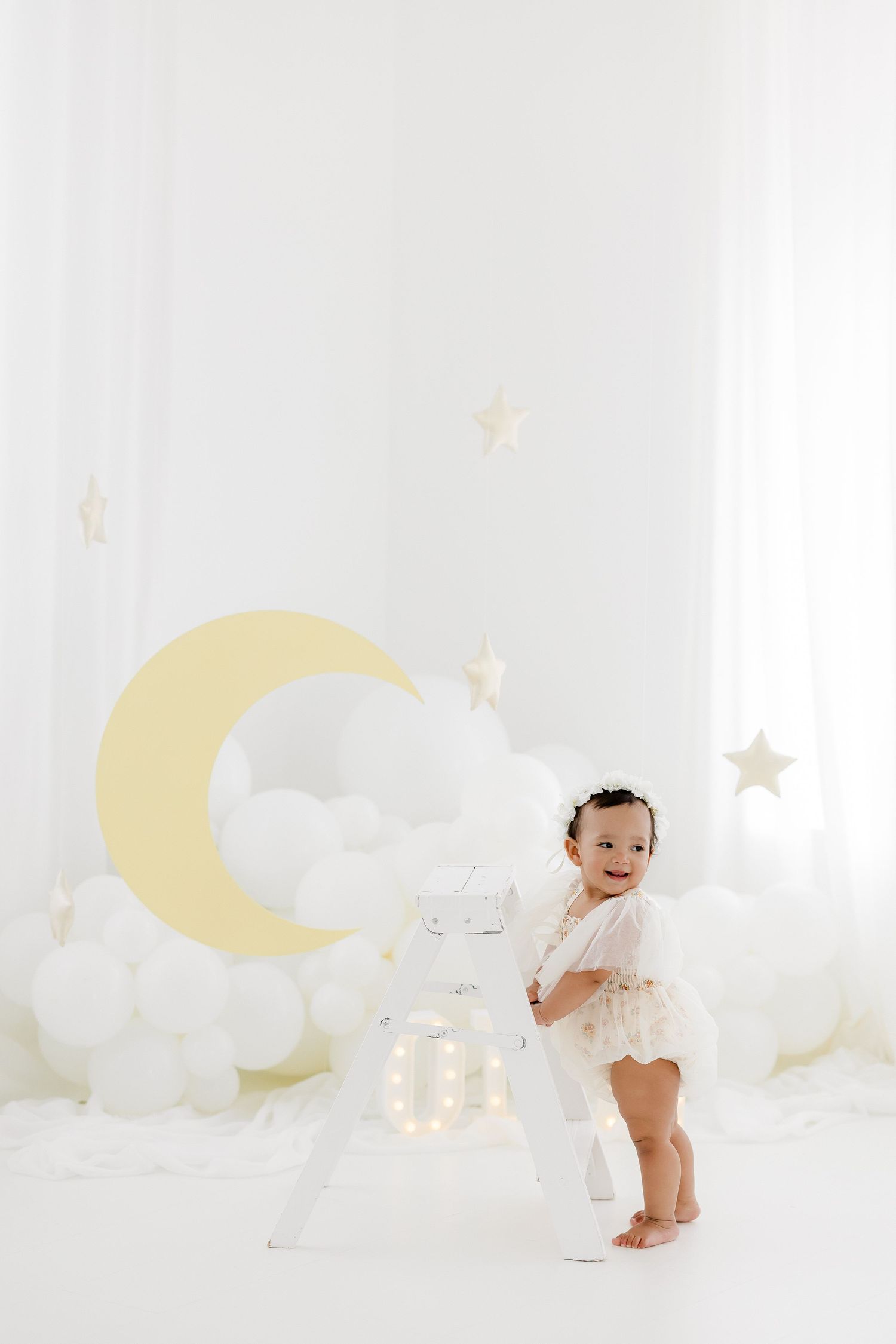 Dreamy celestial themed photoshoot with moon and star decorations.