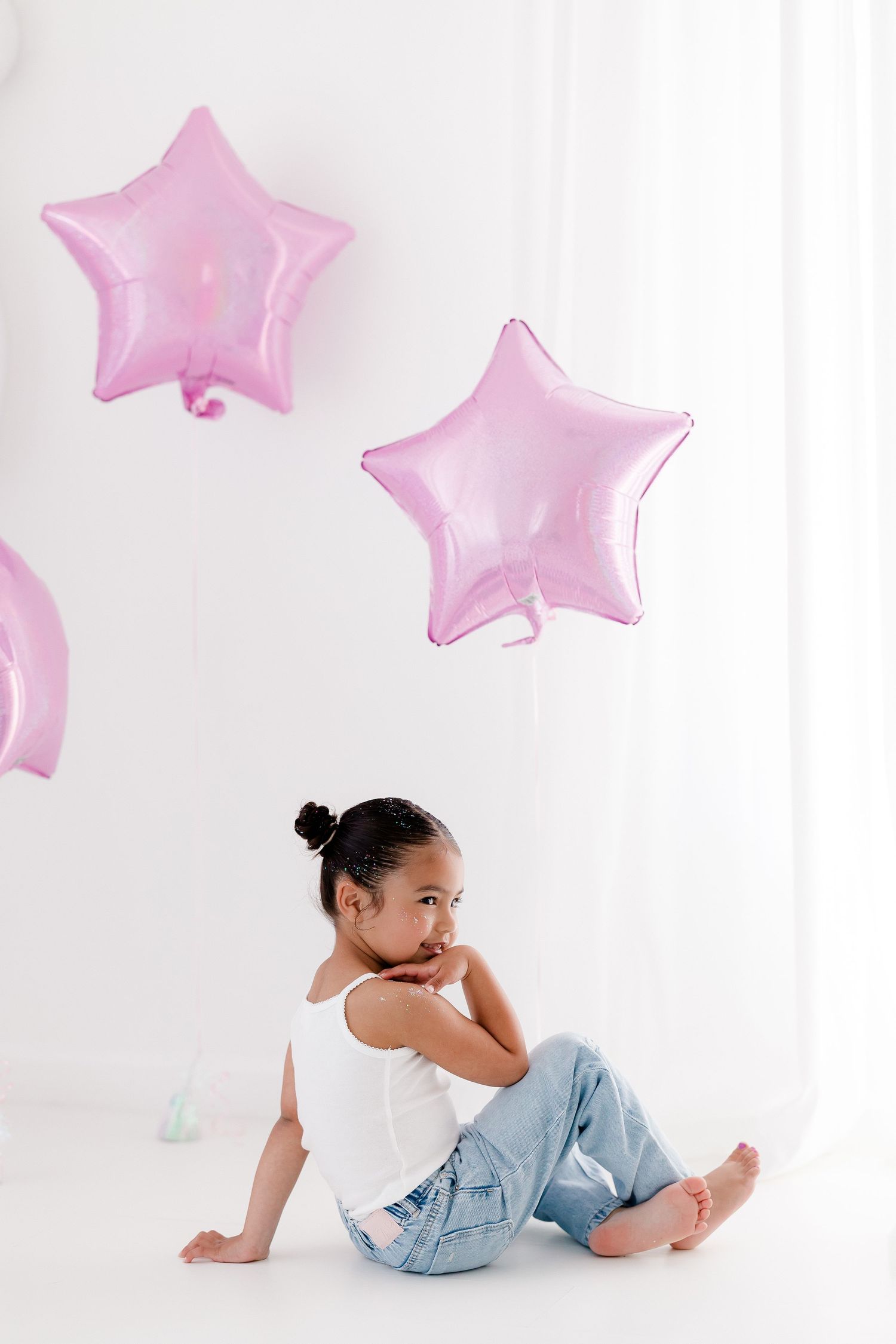 Artistic photo series with pink star balloons and soft lighting against white backdrop creating dreamy atmosphere.