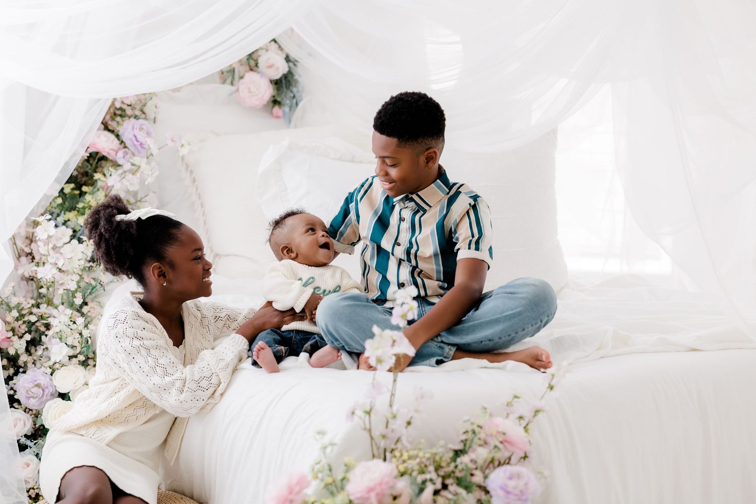 A series of tender moments captured in a bright white studio setting with floral decorations and soft lighting.