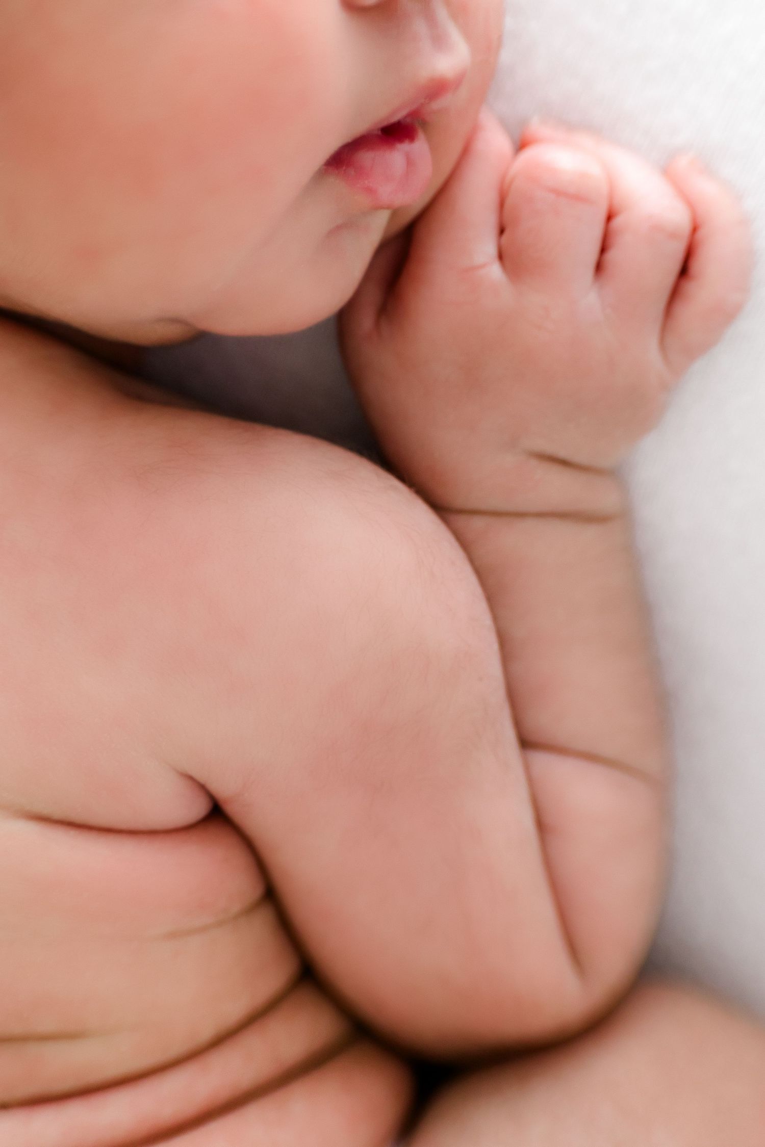 Close-up artistic shots of baby skin folds and features against white background.