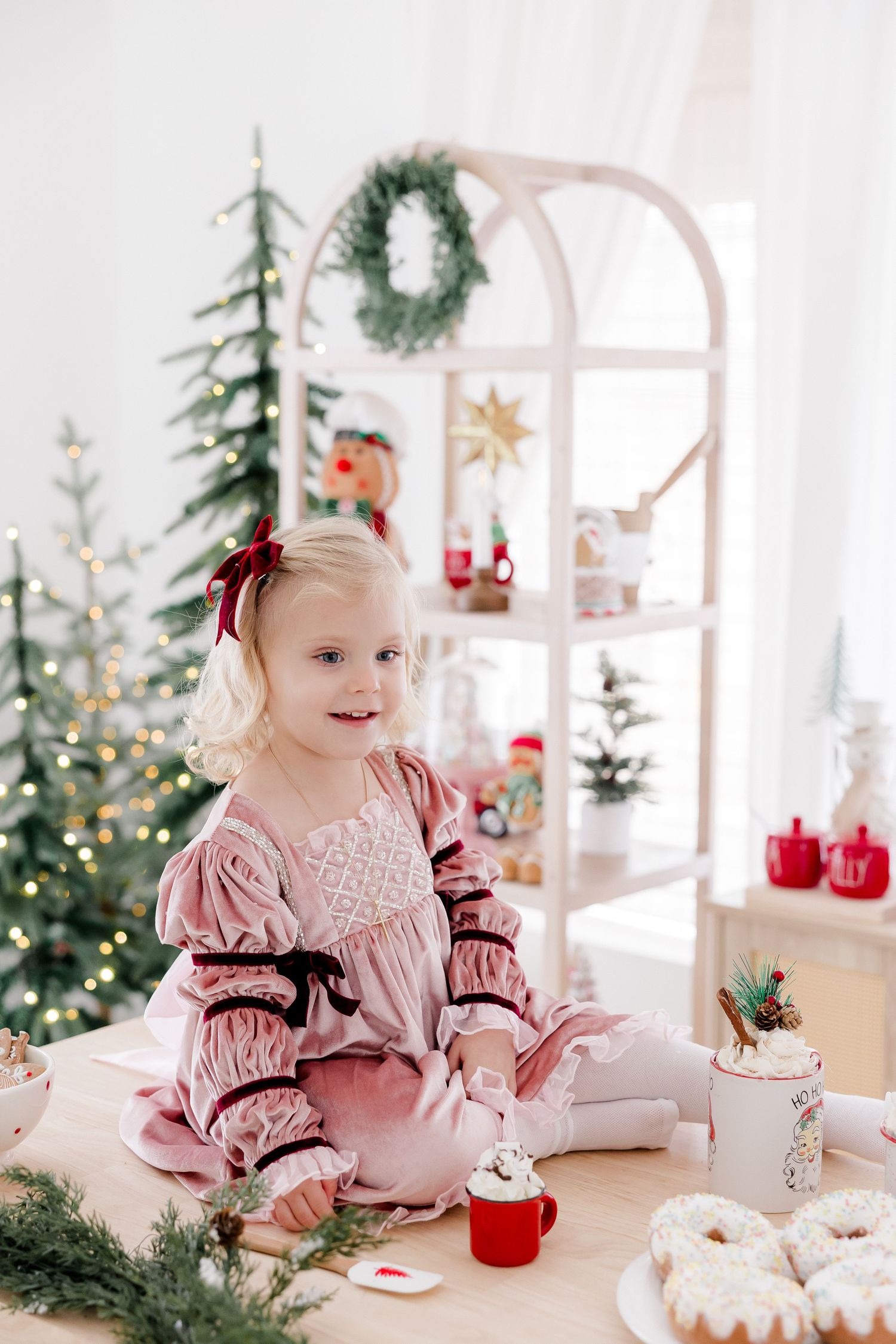Festive Christmas tea party setup with pink decor and holiday treats.