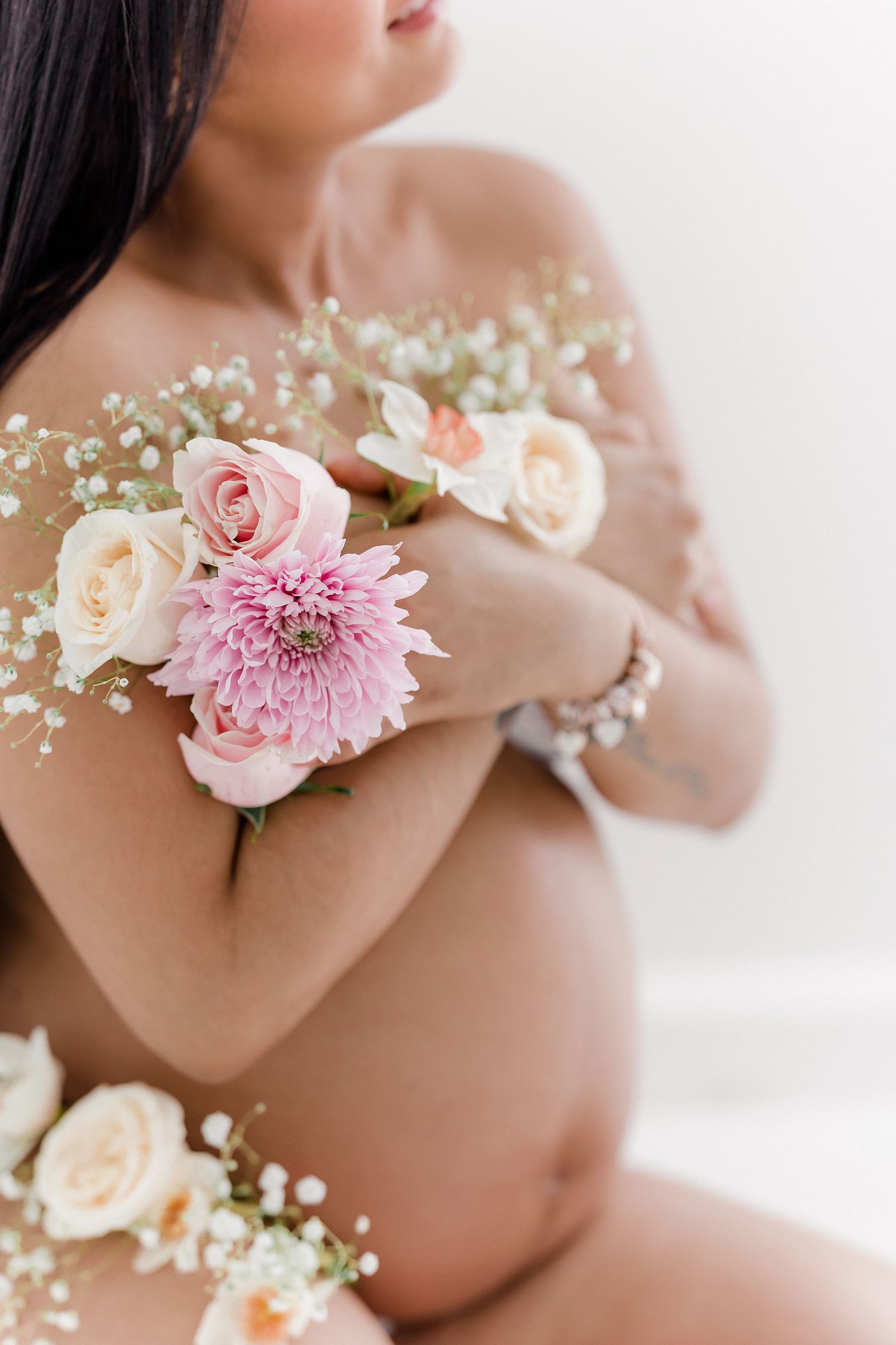 Close-up shots of pink and white flowers decorating a maternity photo session.
