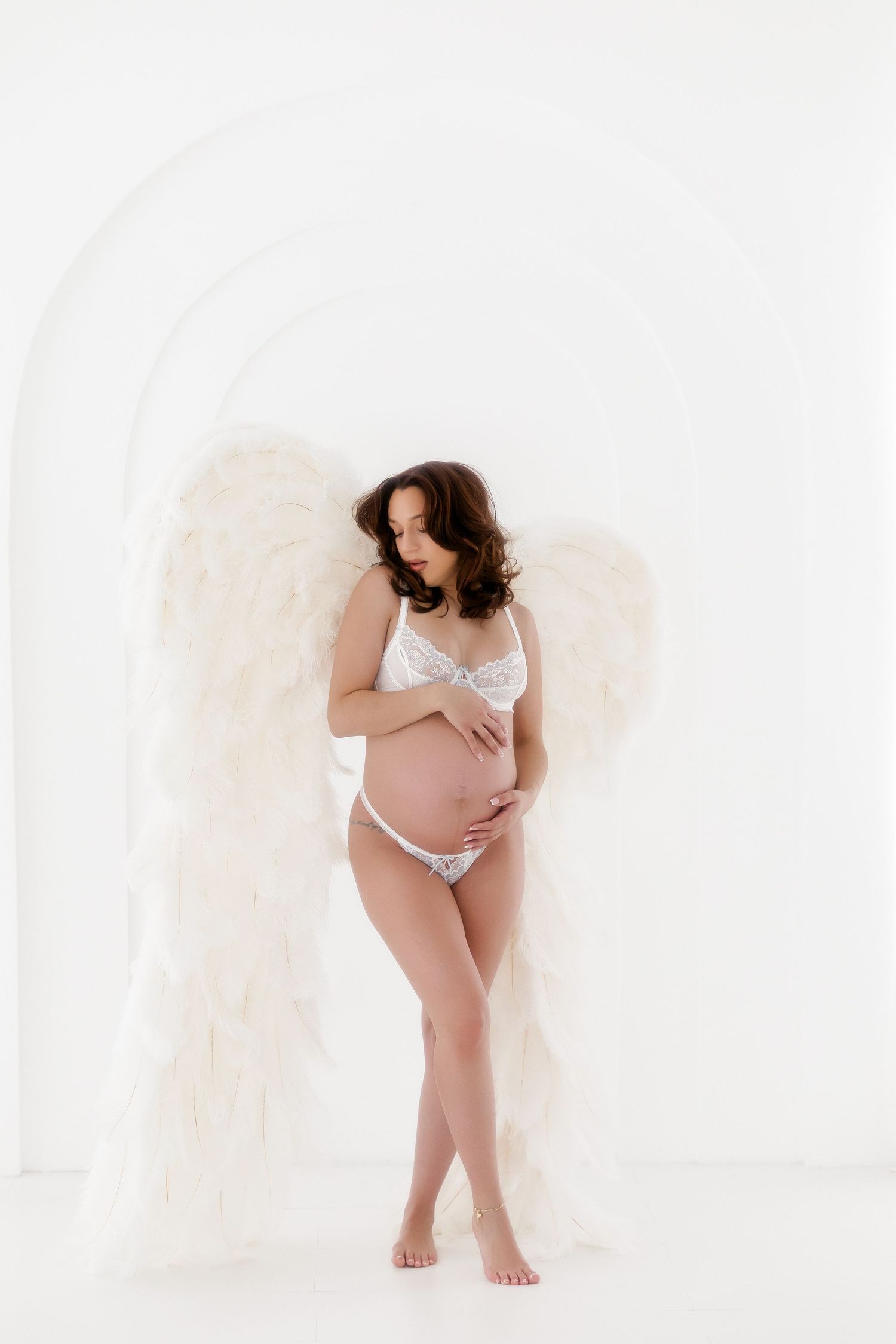 Artistic maternity photography series showing silhouette poses against white backdrop.