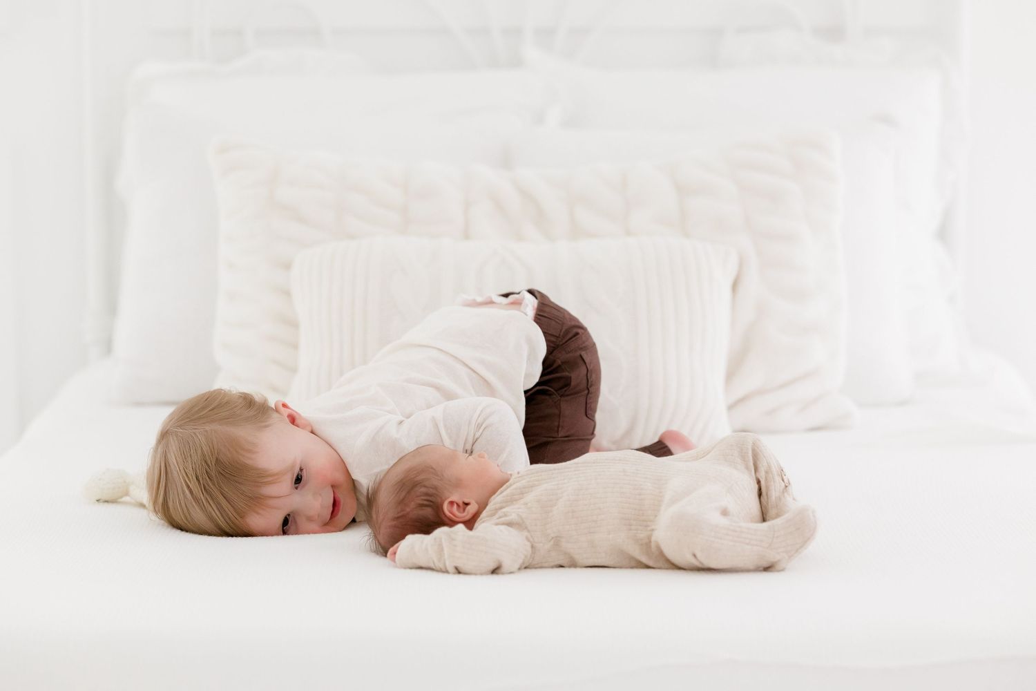 Peaceful indoor maternity photography session with soft white decor and natural lighting.
