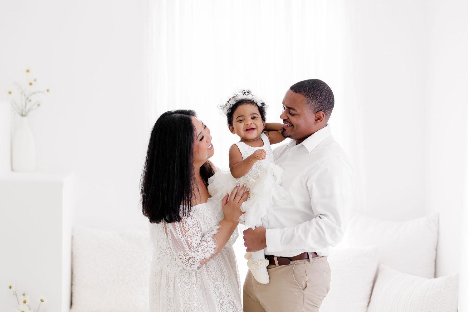 A series of romantic wedding photos showing tender moments between a couple in white against a light background.