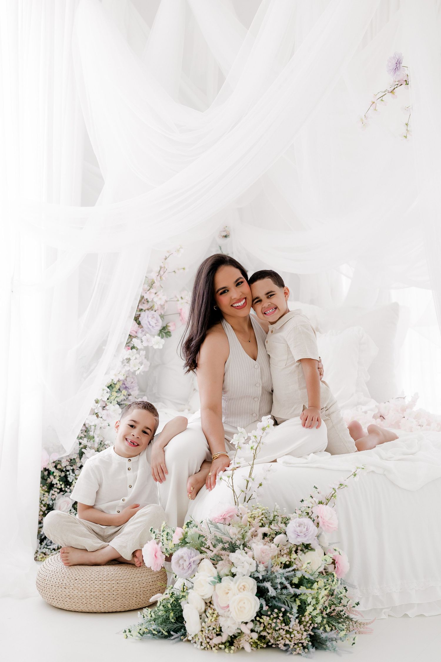 A tender family portrait session in white featuring soft floral arrangements and natural woven accents.