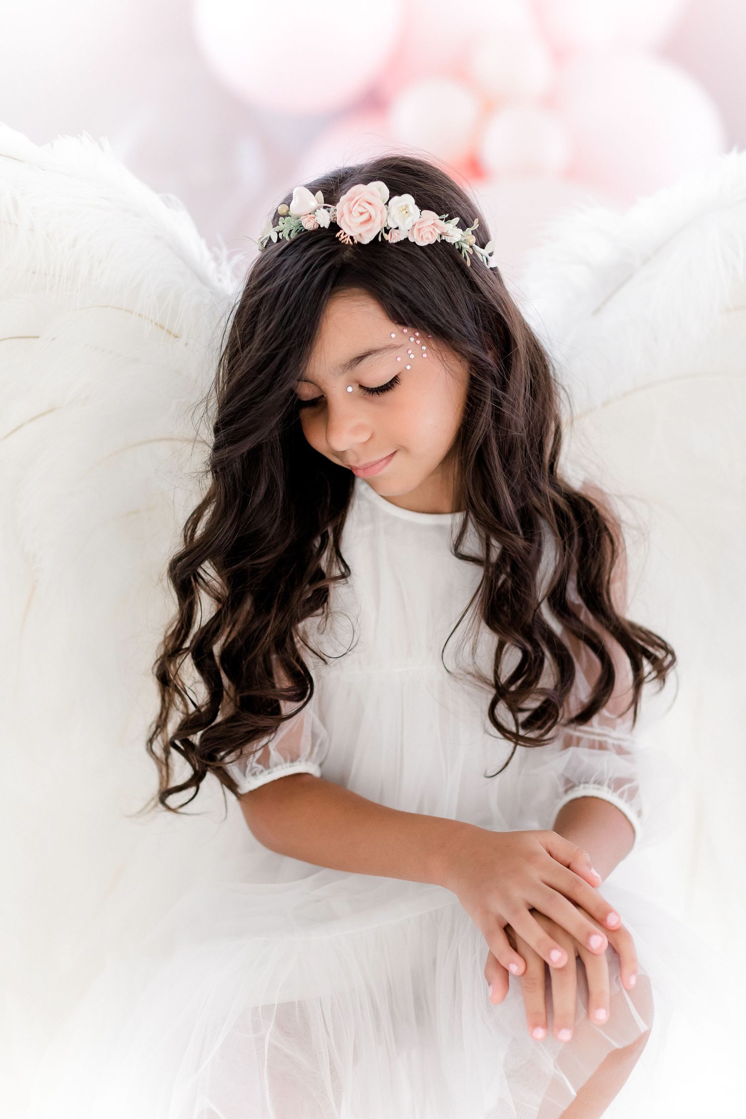 Ethereal portrait series of someone wearing a white dress and floral crown against soft dreamy lighting and white backdrop.