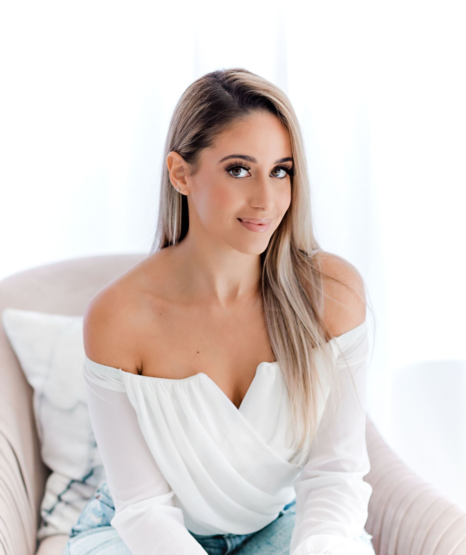 Portrait session featuring woman in white top against bright studio backdrop.