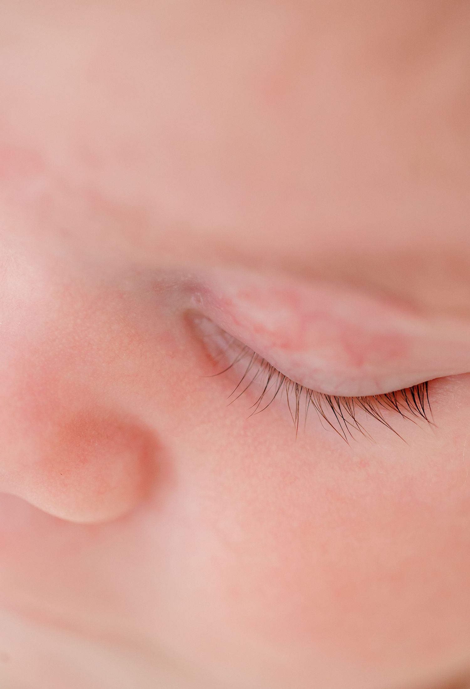 Close up macro shot of soft pink baby skin showing delicate textures.