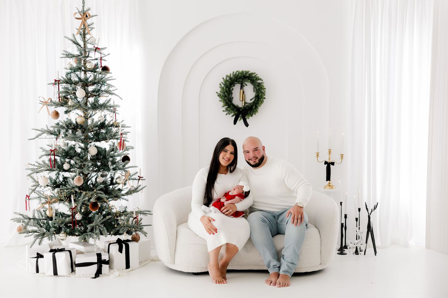 Modern Christmas photoshoot setup with minimalist white decor and evergreen tree.