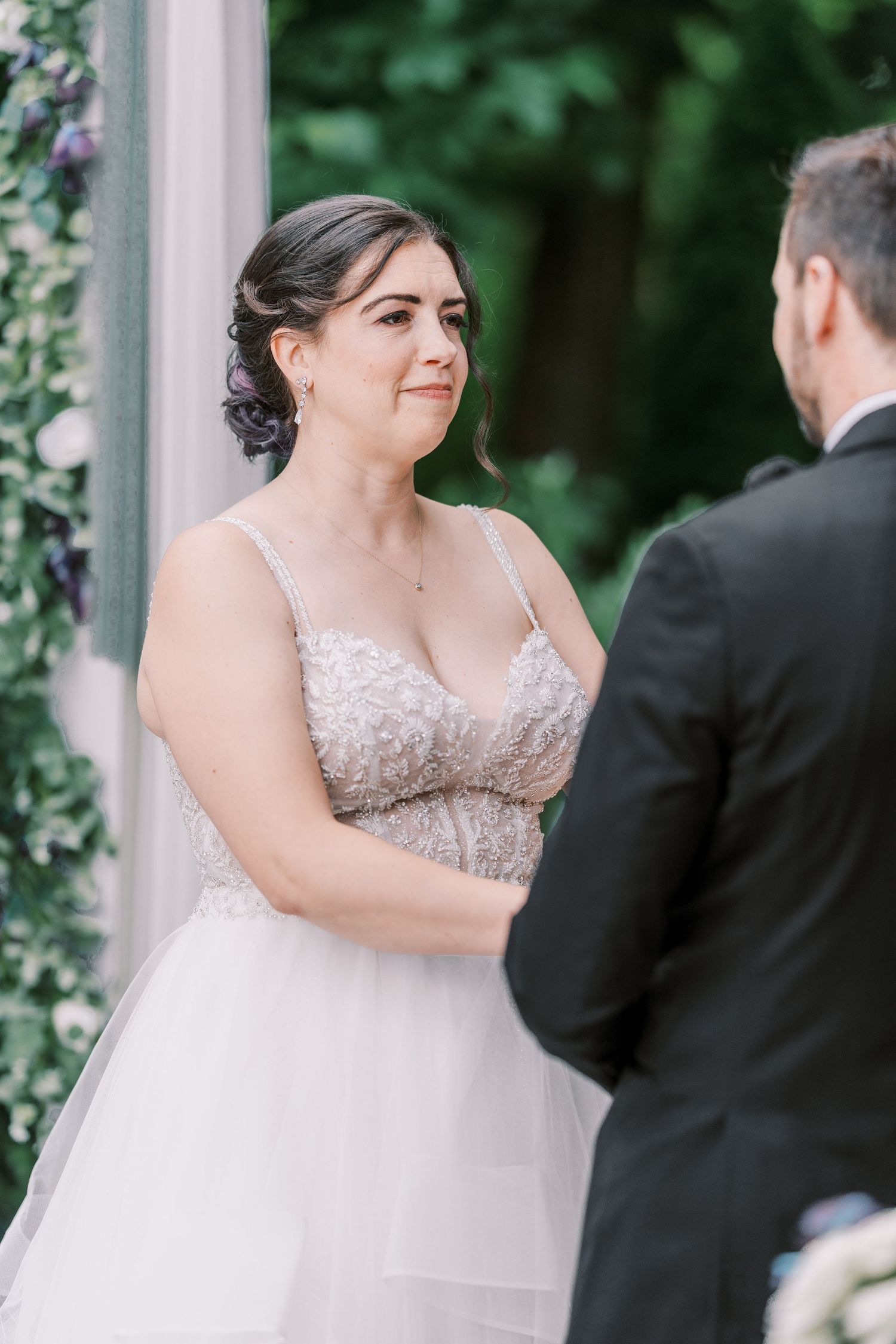 Bride in an embellished sleeveless wedding gown sharing a romantic first dance moment during outdoor garden reception.