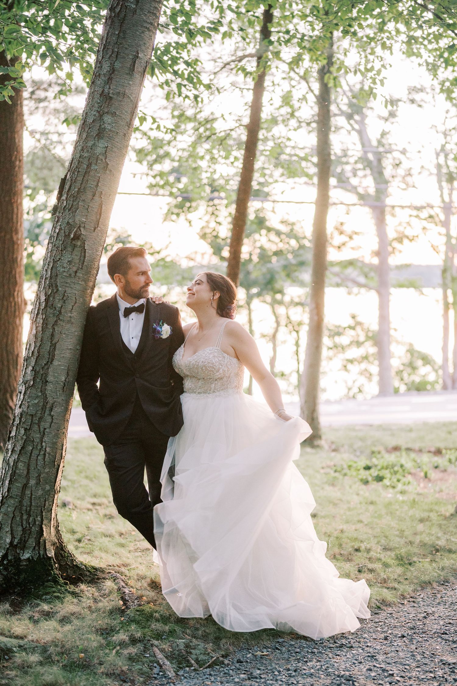 Romantic wedding couple dances together in a dreamy forest setting during golden hour.