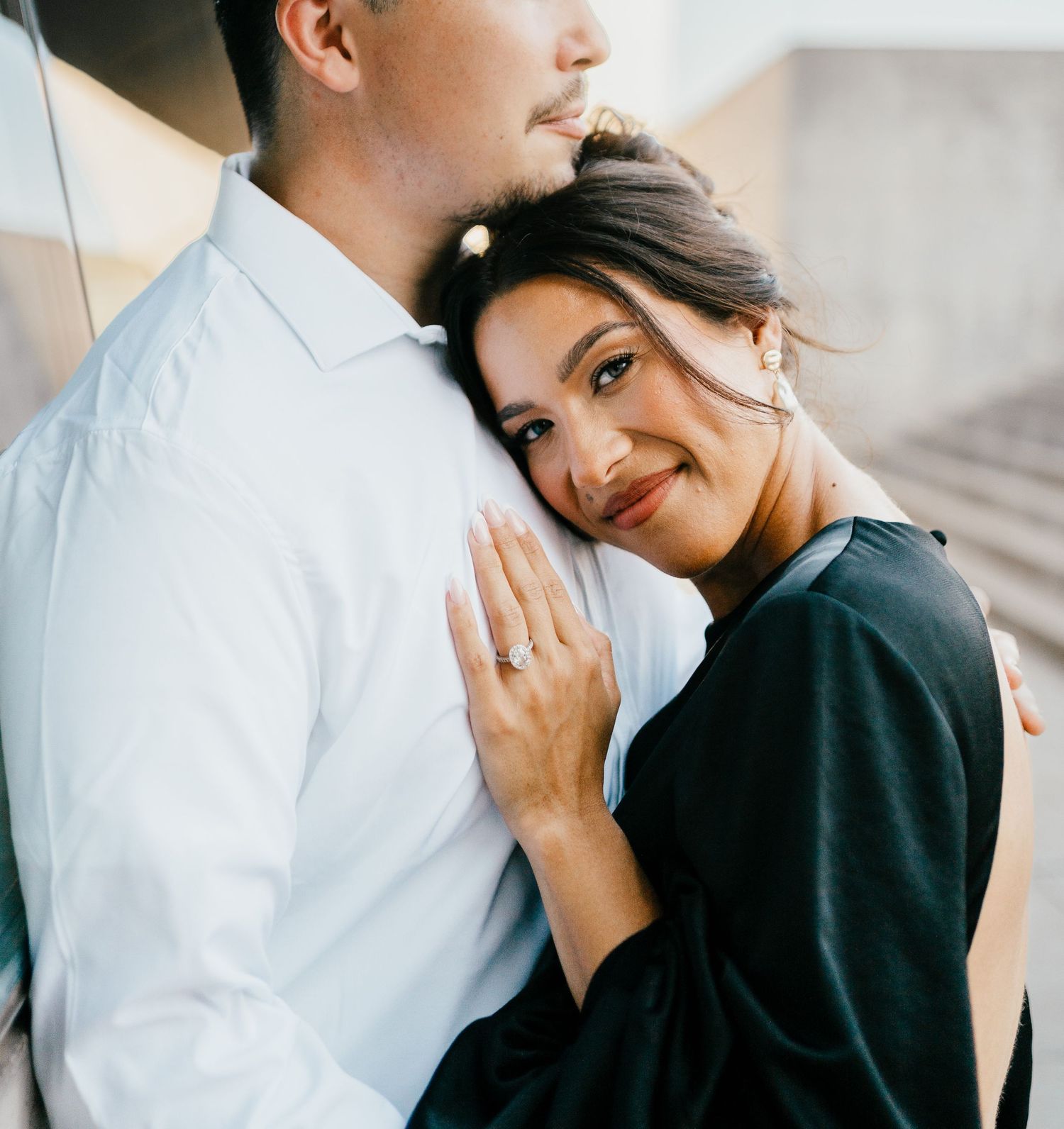 Young couple in black and white outfits sharing intimate moments in romantic engagement photo series.