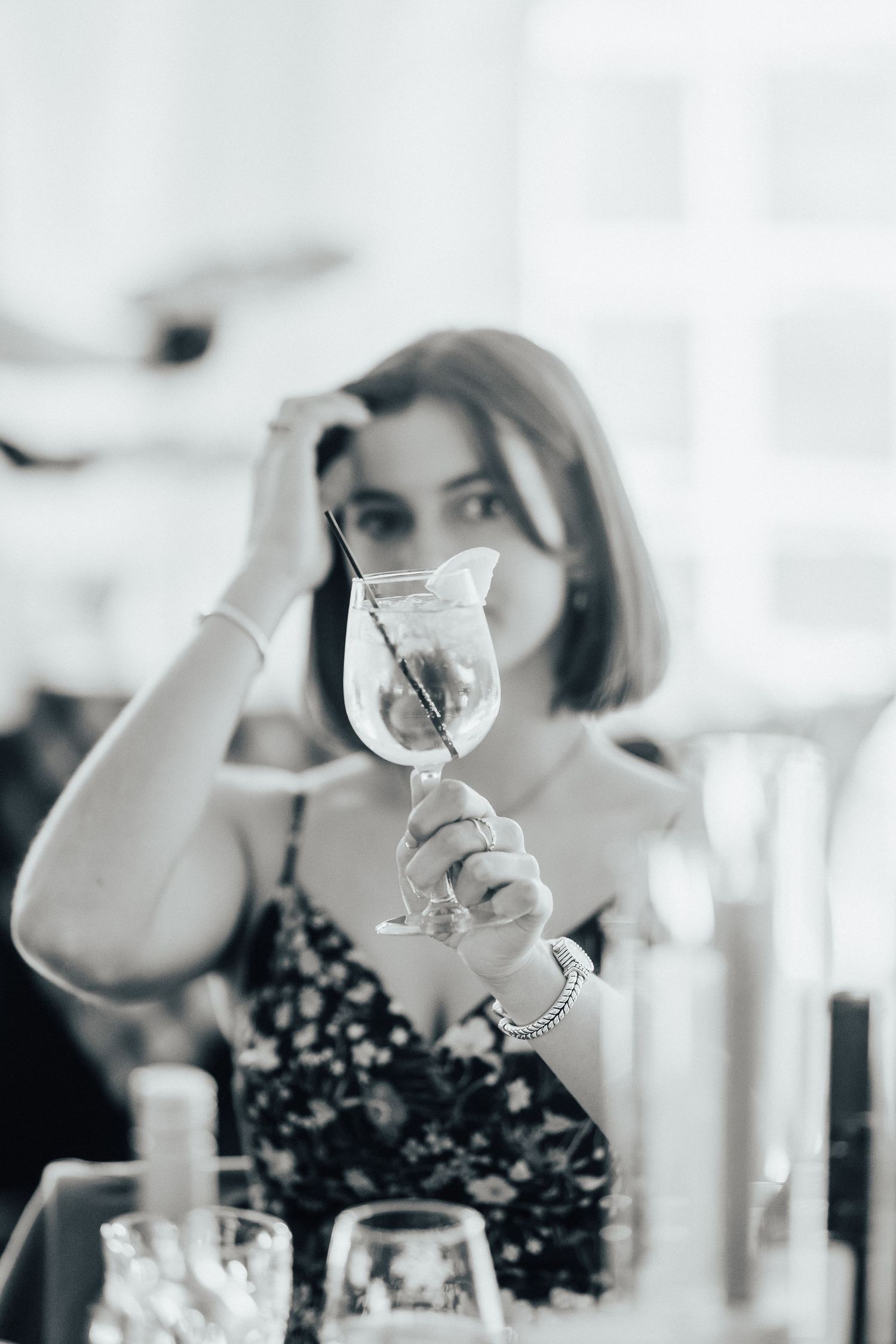 A series of black and white photographs showing wine glasses being held up in a celebratory setting.