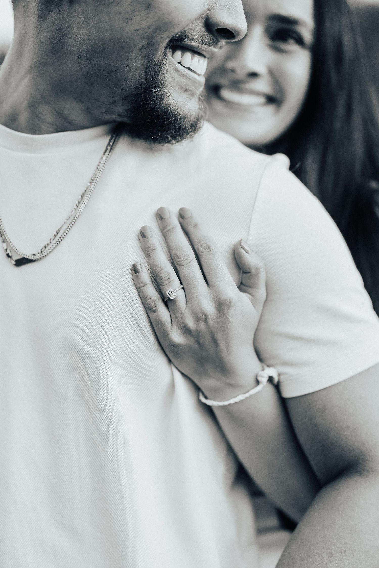 Intimate black and white close-up of a couple sharing a tender moment while wearing casual white attire.