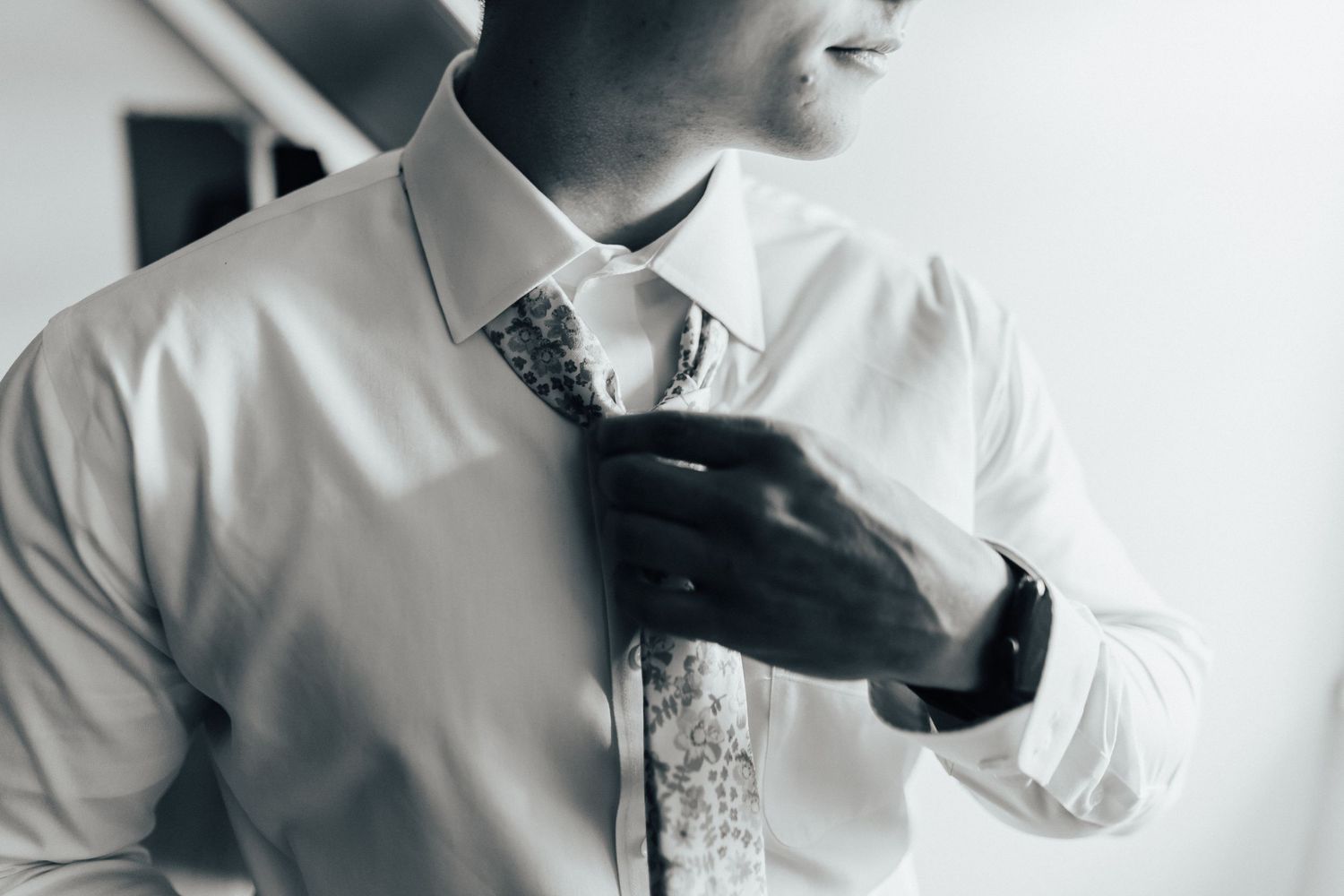 Professional executive in a crisp white button-down shirt gestures thoughtfully during a business conversation.