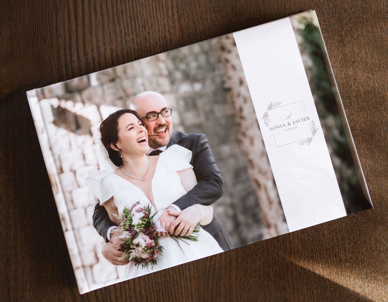 Fotografía artística de un álbum de bodas de lujo iluminado por luz natural.