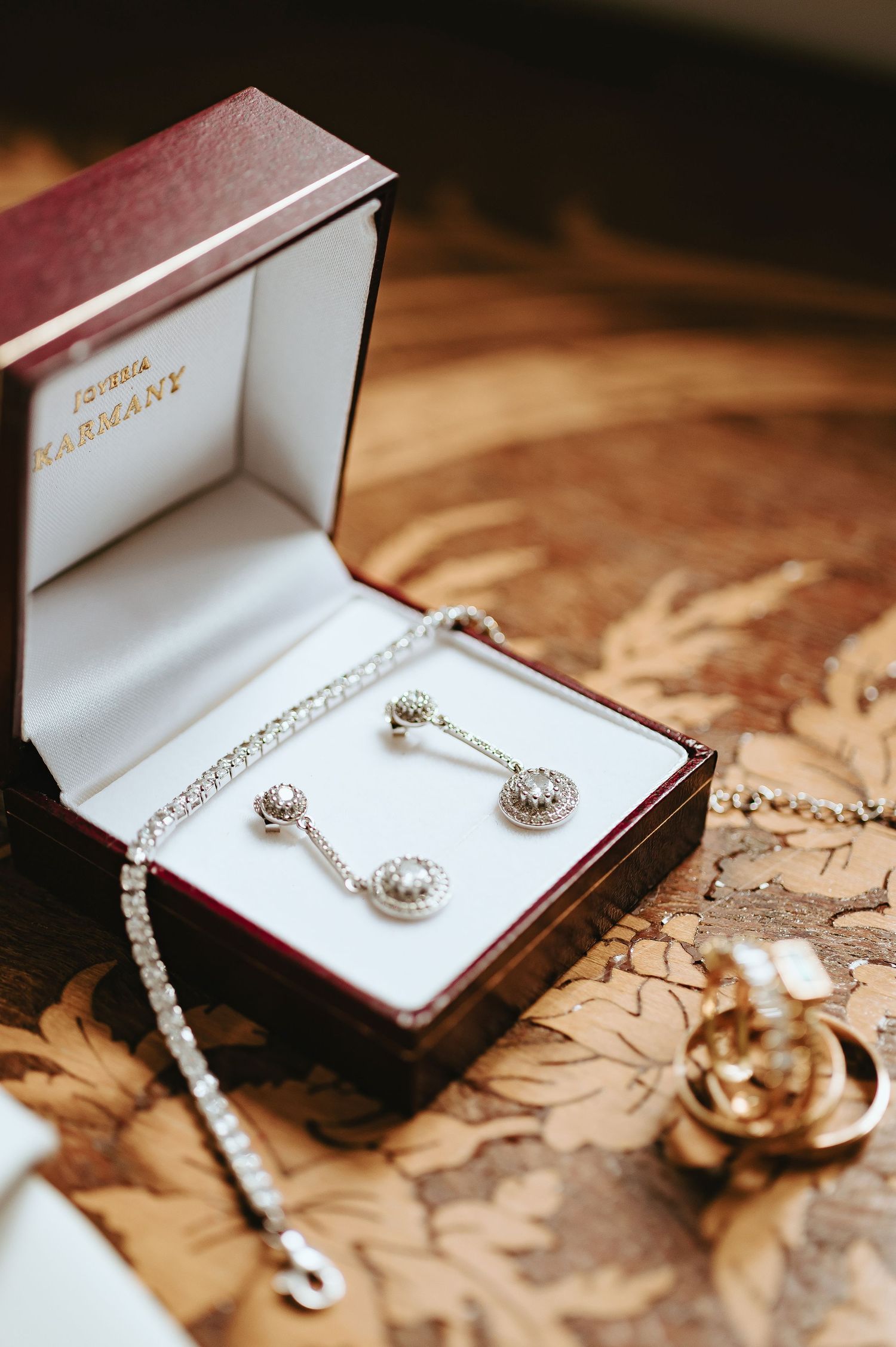 Fotografía de producto de pendientes largos para novia con diamantes brillantes sobre fondo neutro.