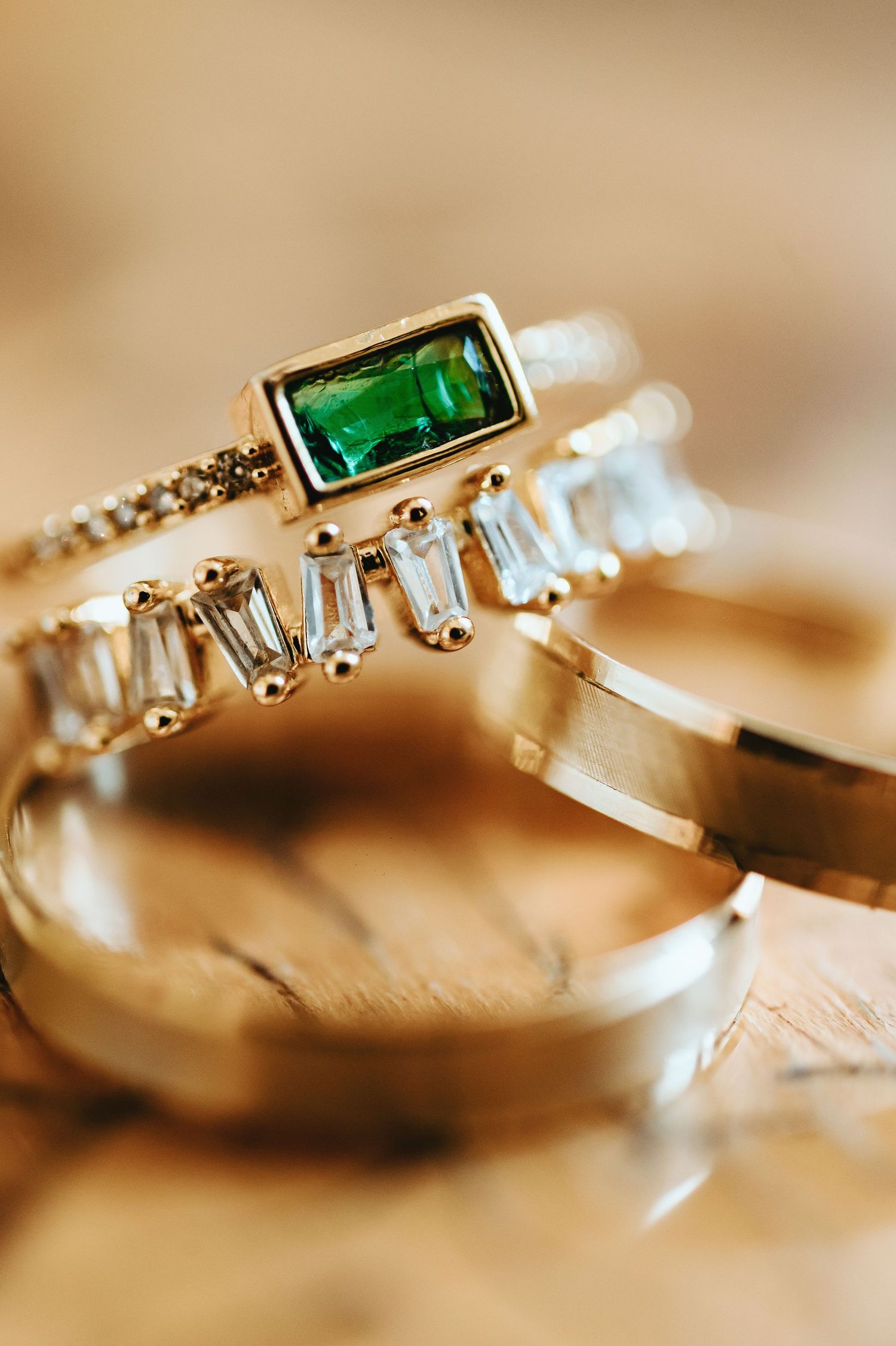 Anillo de pedida en oro con pavé de diamantes brillantes, esmeralda y alianzas de boda.