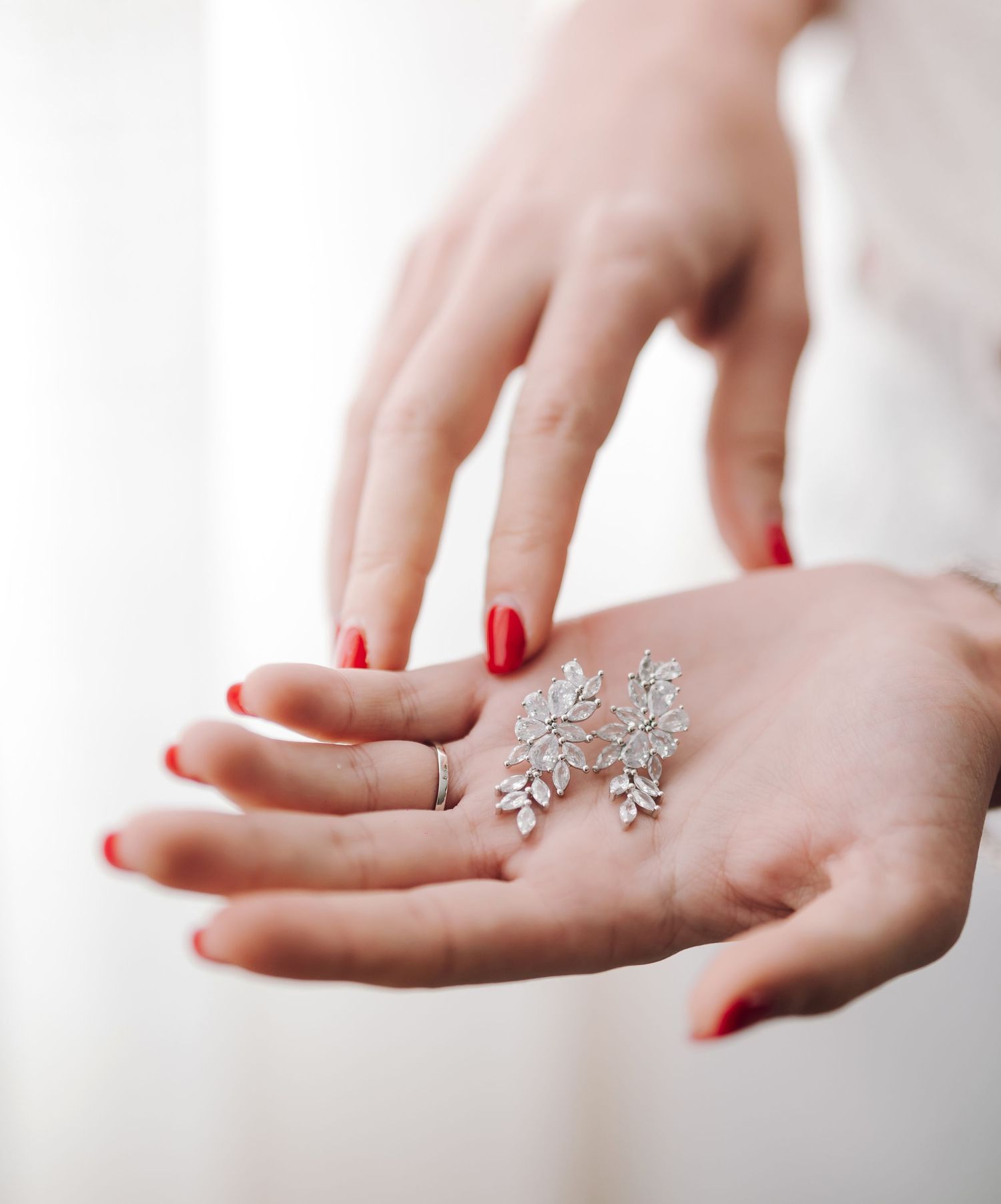 Detalle de pendientes con diseño exclusivo de flores y pequeños brillantes calados.