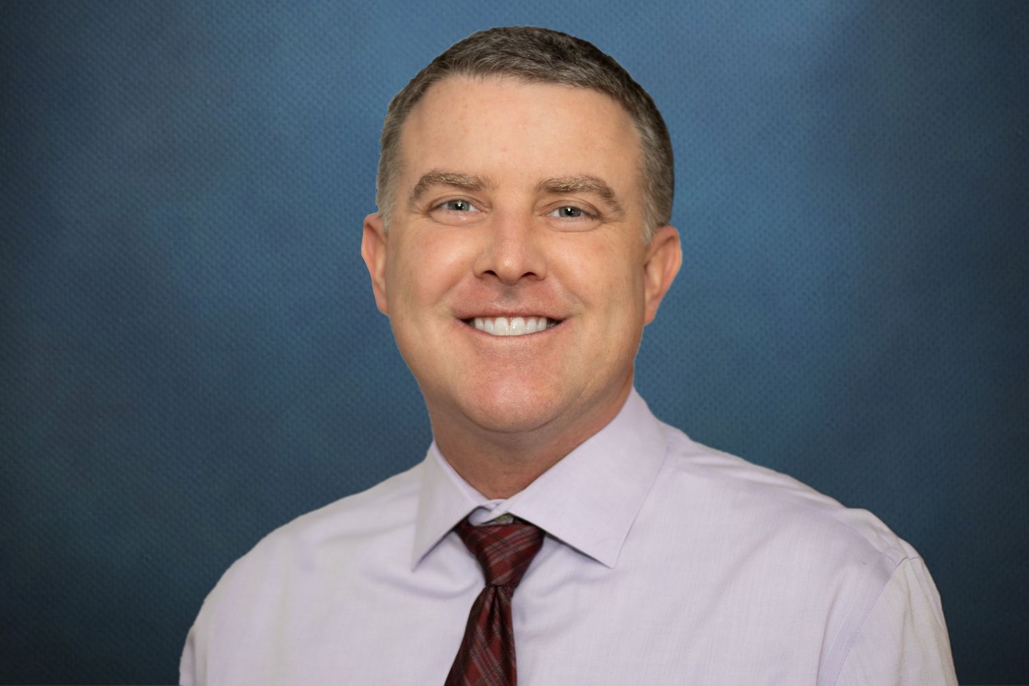 An image of a man in a shirt and tie.