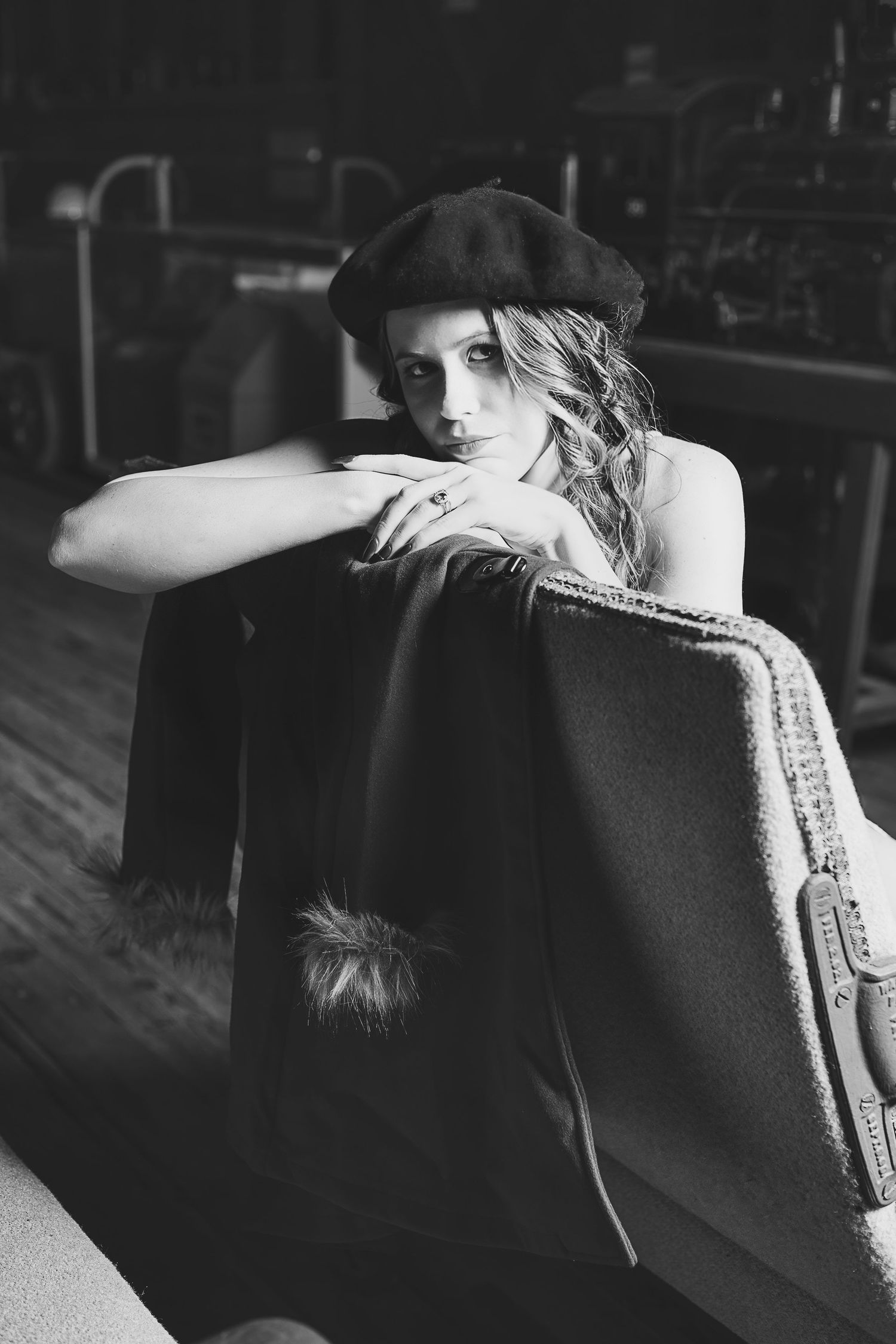 Moody black and white portrait featuring beret and dramatic lighting in indoor setting.