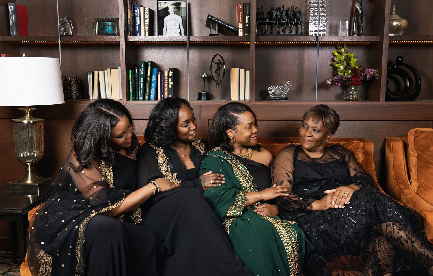 A group of people in green outfits celebrate and embrace at what appears to be a social gathering or party.