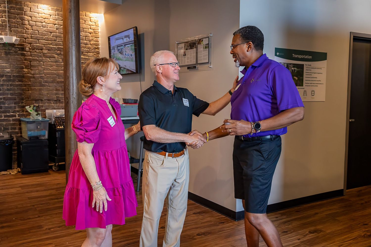 Three people engaged in conversation at casual networking event.