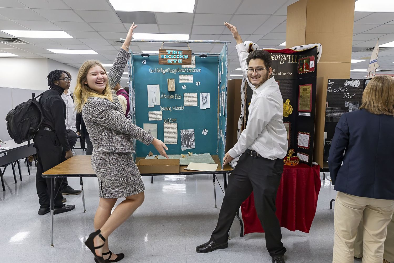Students engaging in dynamic poses during a classroom presentation or event.