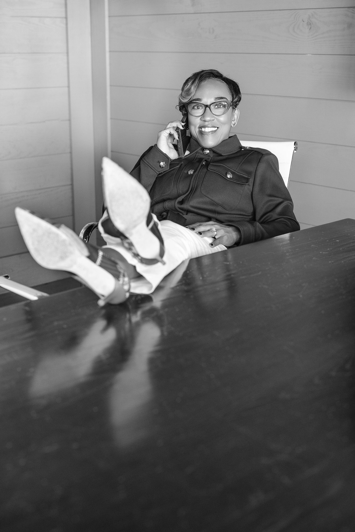 A black and white sequence of four photos showing someone reclining on a couch while reading a book.