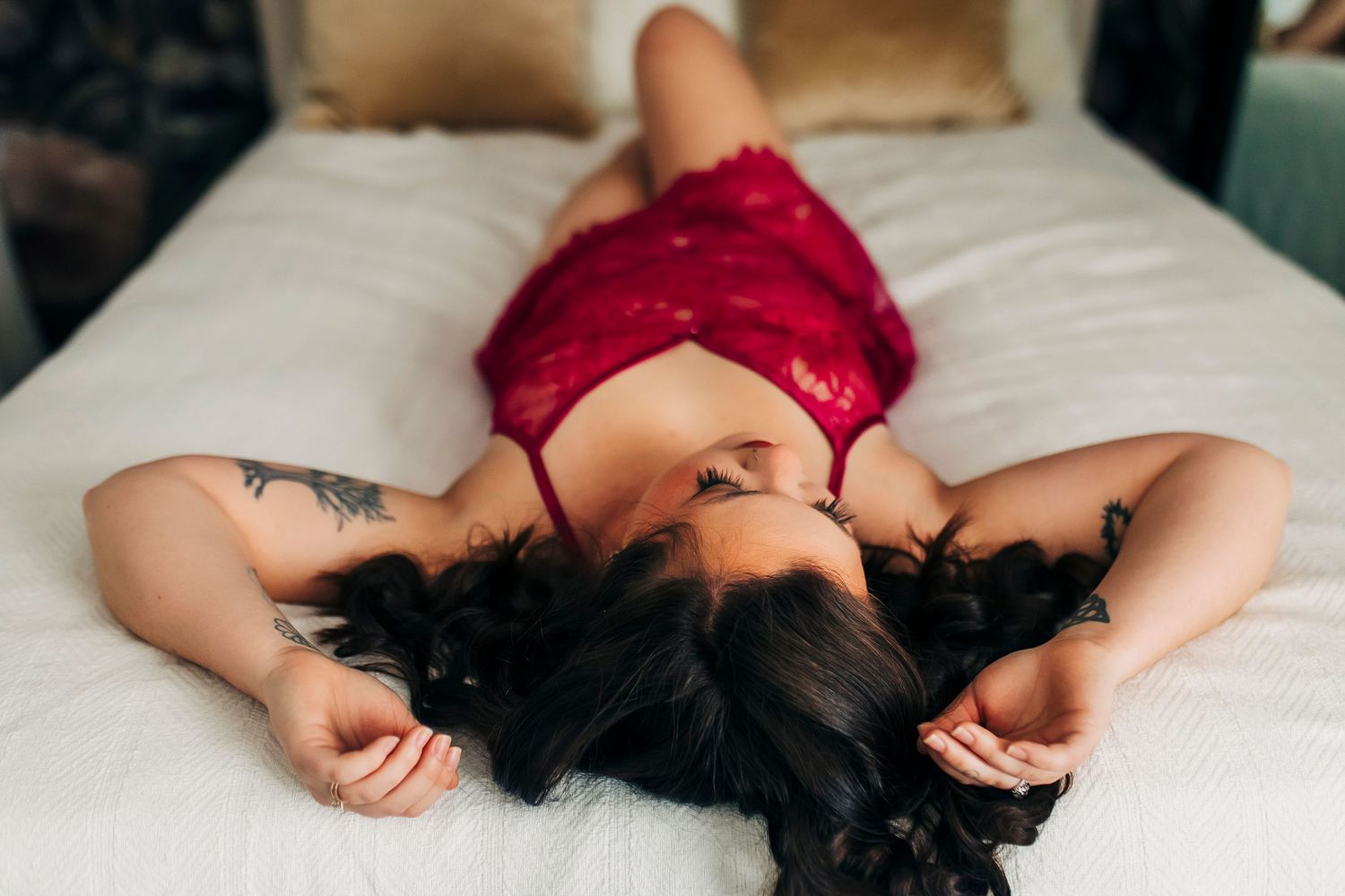Boudoir pose on white sheets in softly lit in-home Republic Missouri studio.