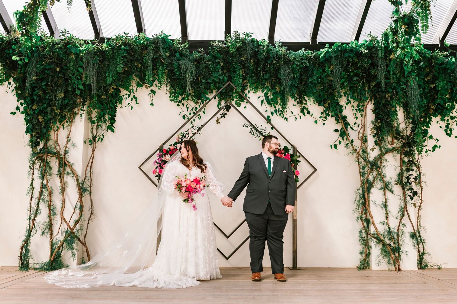 Bride and groom waiting for the ceremony at Green House Two Rivers in Highlandville Missouri surrounded by greenery.