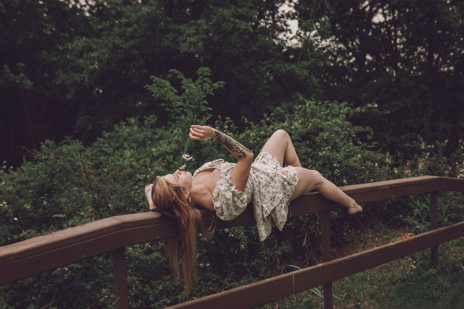 Sequence of parkour images showing graceful backflip movement over a wooden rail in an outdoor wooded setting.