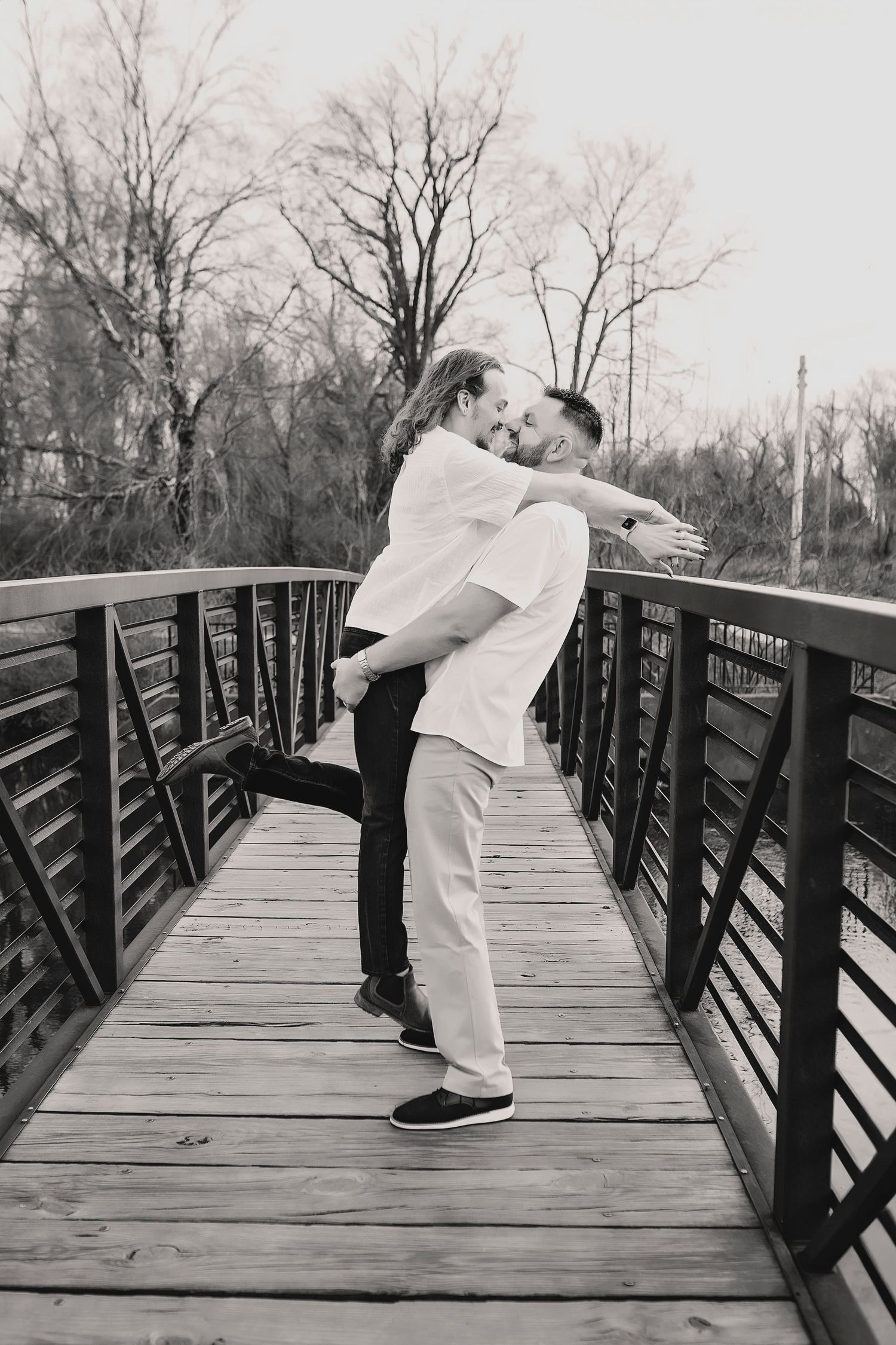 Tasteful black and white image of two men holding each other in safe space.