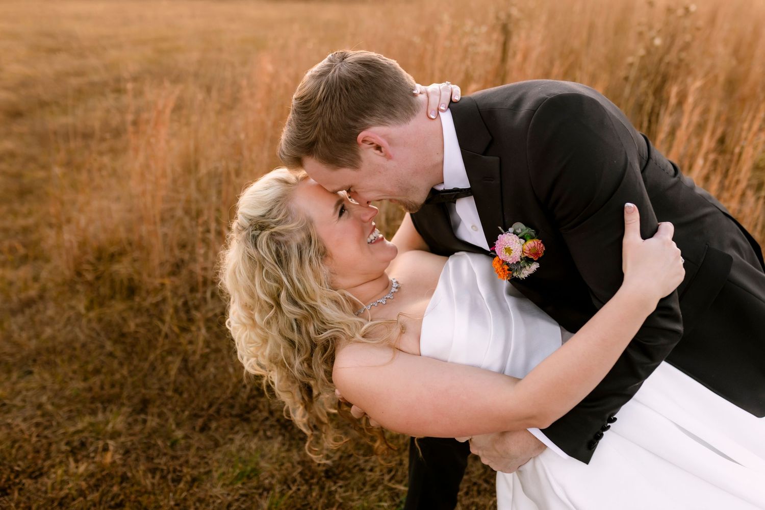 Couple shares passionate kiss during sunset wedding photoshoot at Southern Charm Estates in Missouri.