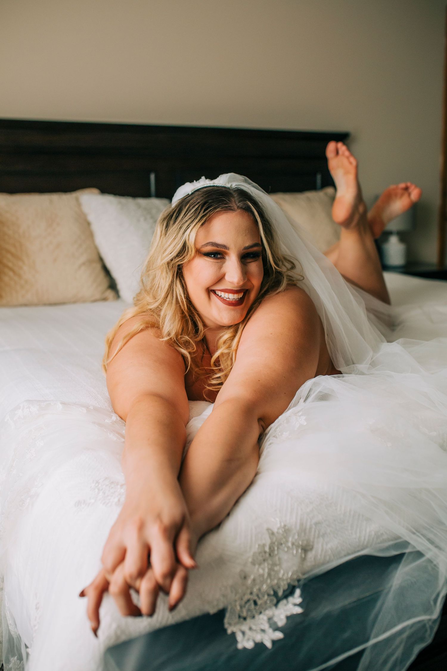 Close-up of confident smile during bridal boudoir session in natural light studio.