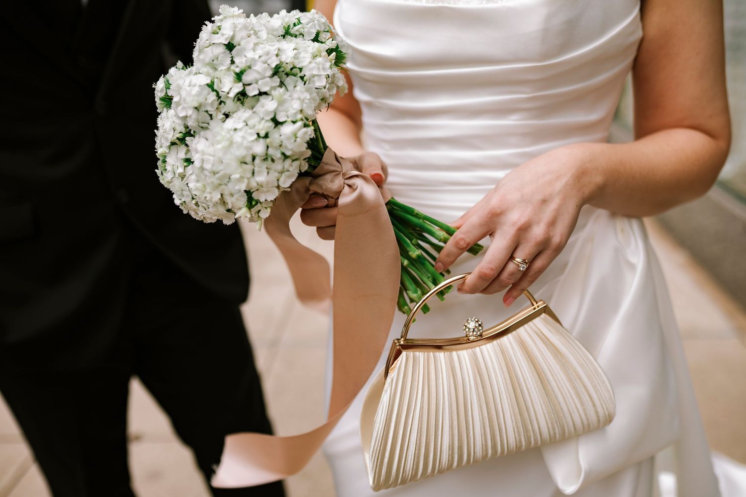 Bride holds her clutch and bouquet outside of the Savoy Ballroom in downtown Springfield MO.