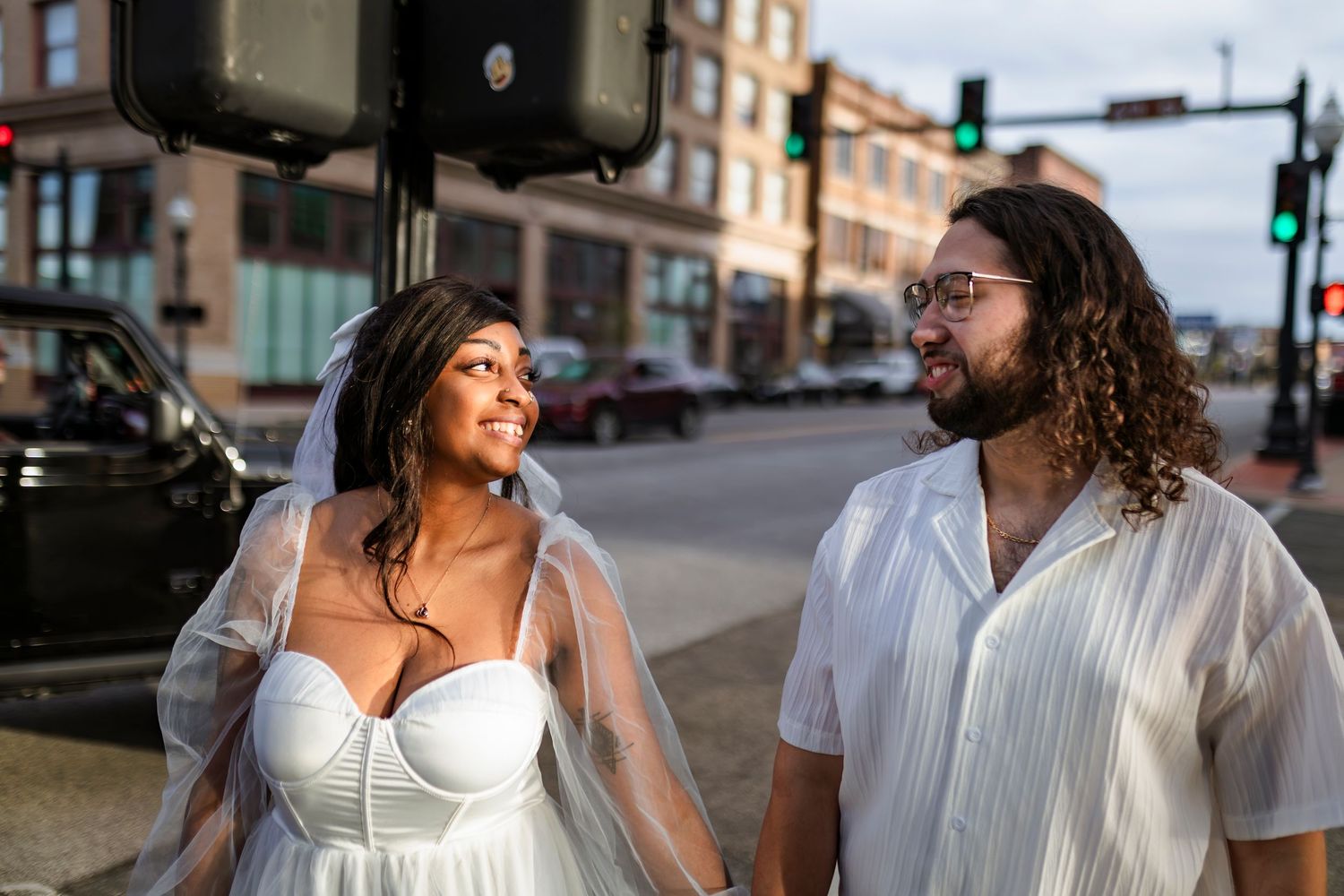 A happy couple shares laughter and intimate moments while walking together through a downtown area.