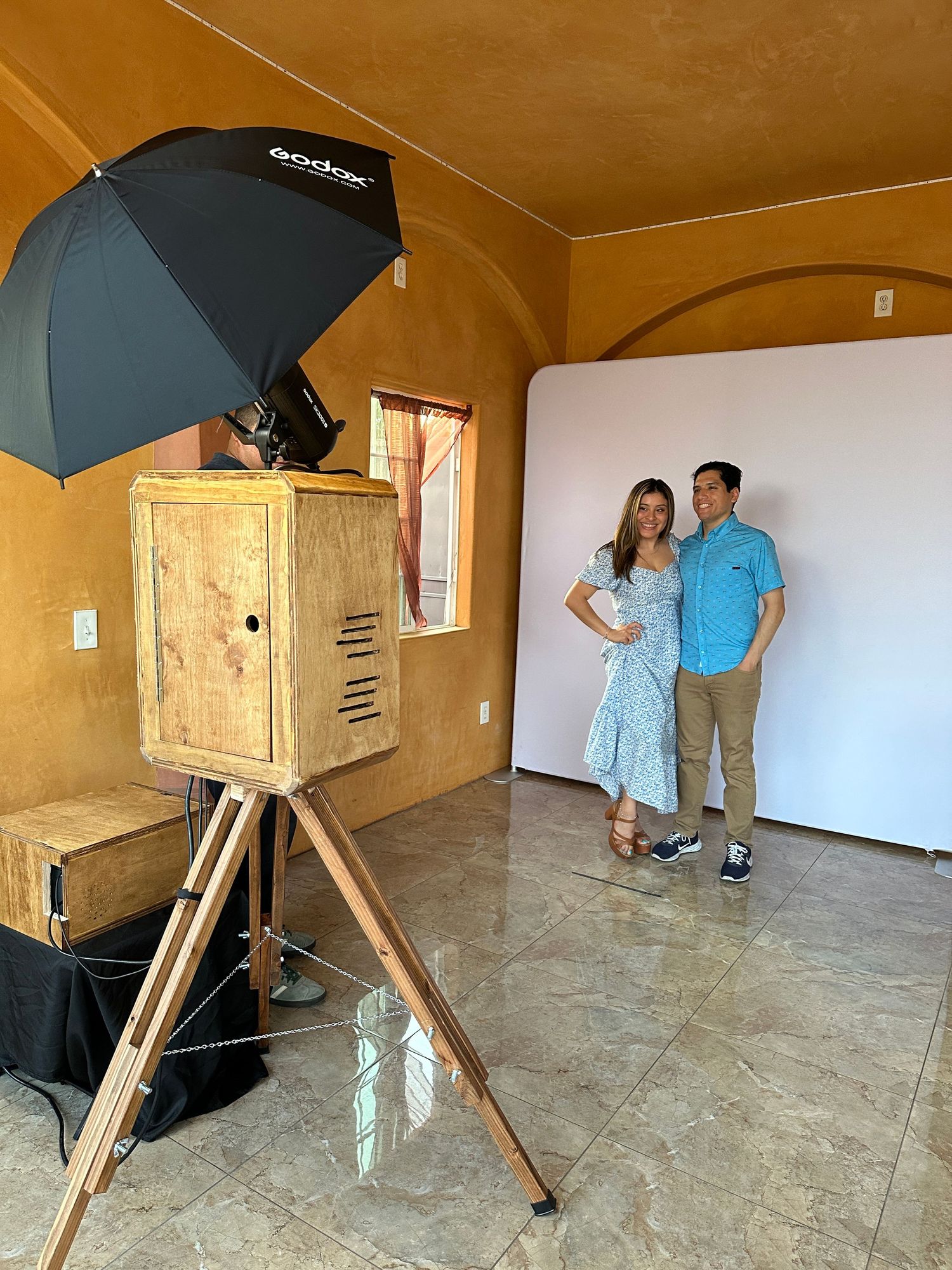 A photo booth set up and a couple pose for a picture
