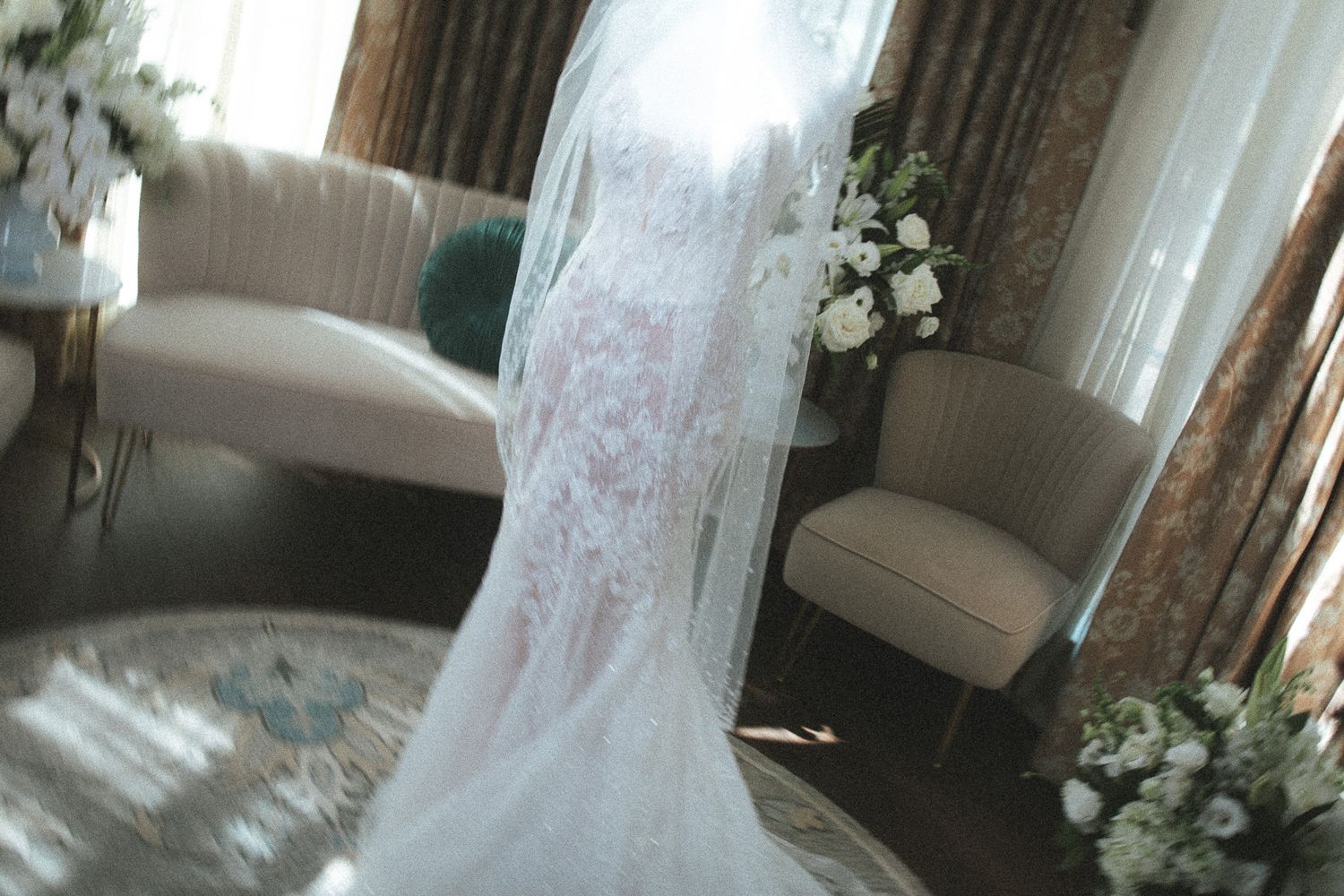 Stunning lace mermaid wedding dress with veil displayed in a beautifully decorated bridal suite.