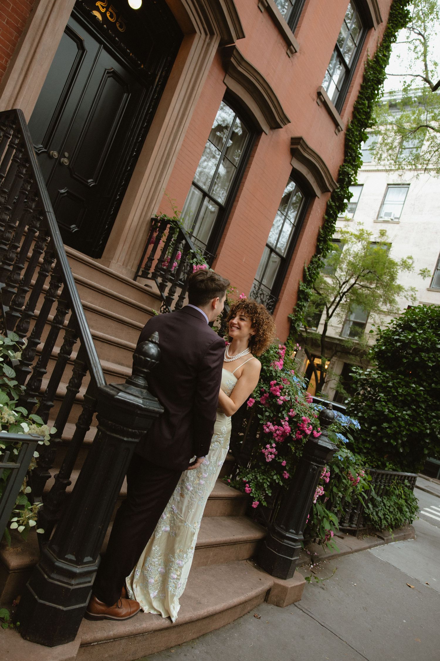 Couple posing outside a brownstone building with classic architecture.