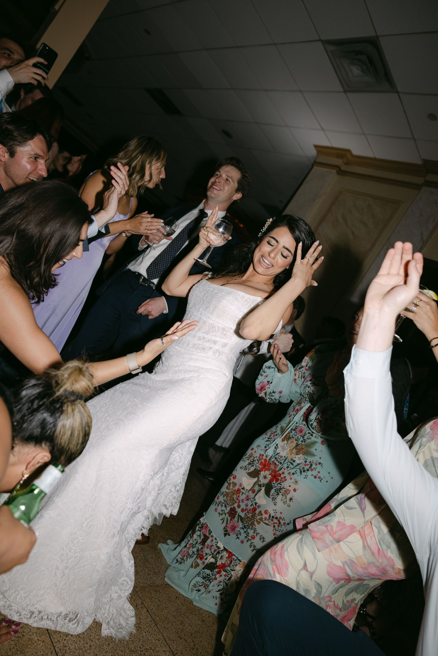Wedding reception dance party with guests celebrating on a dark dance floor.