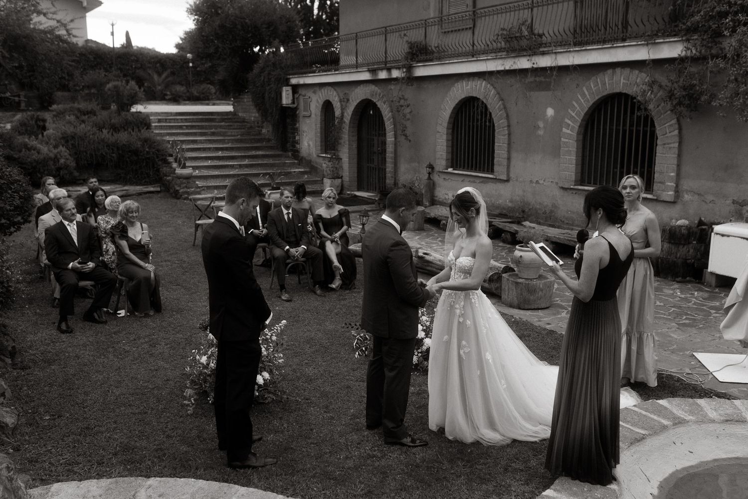 Wedding party gathering outdoors at a traditional venue with stone architecture.