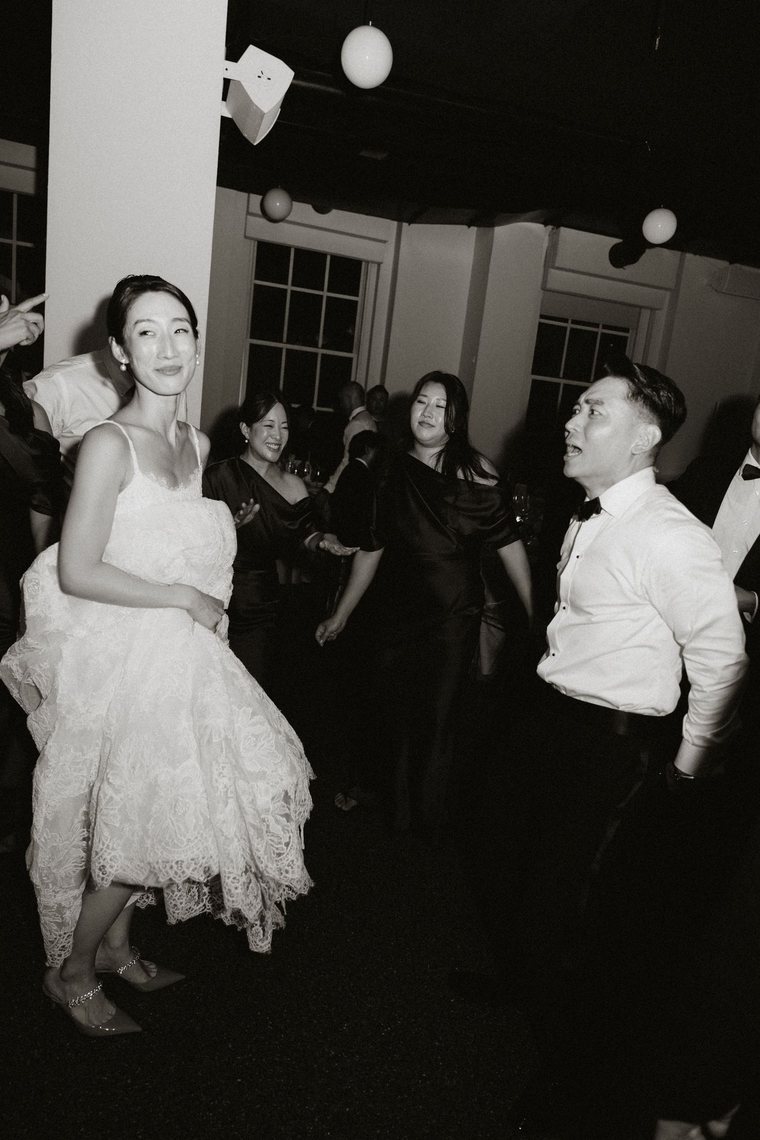 A black and white sequence of a wedding reception dance with twirling movements.
