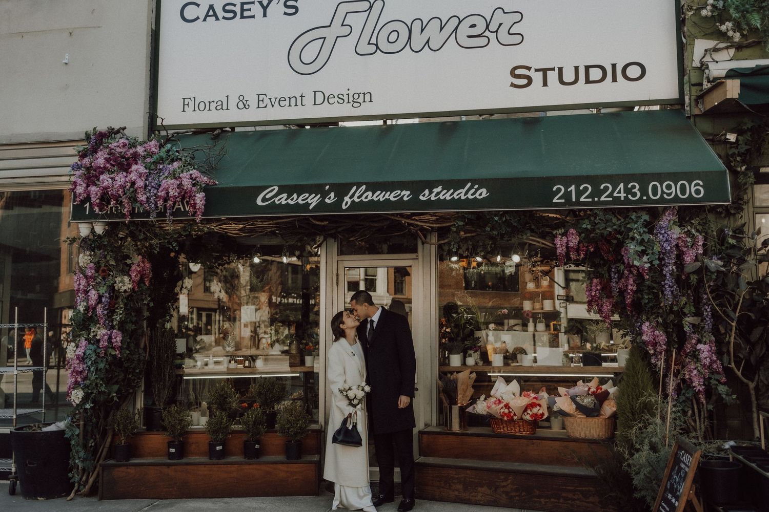 Storefront of Casey's Flower Studio with purple floral displays framing the entrance.
