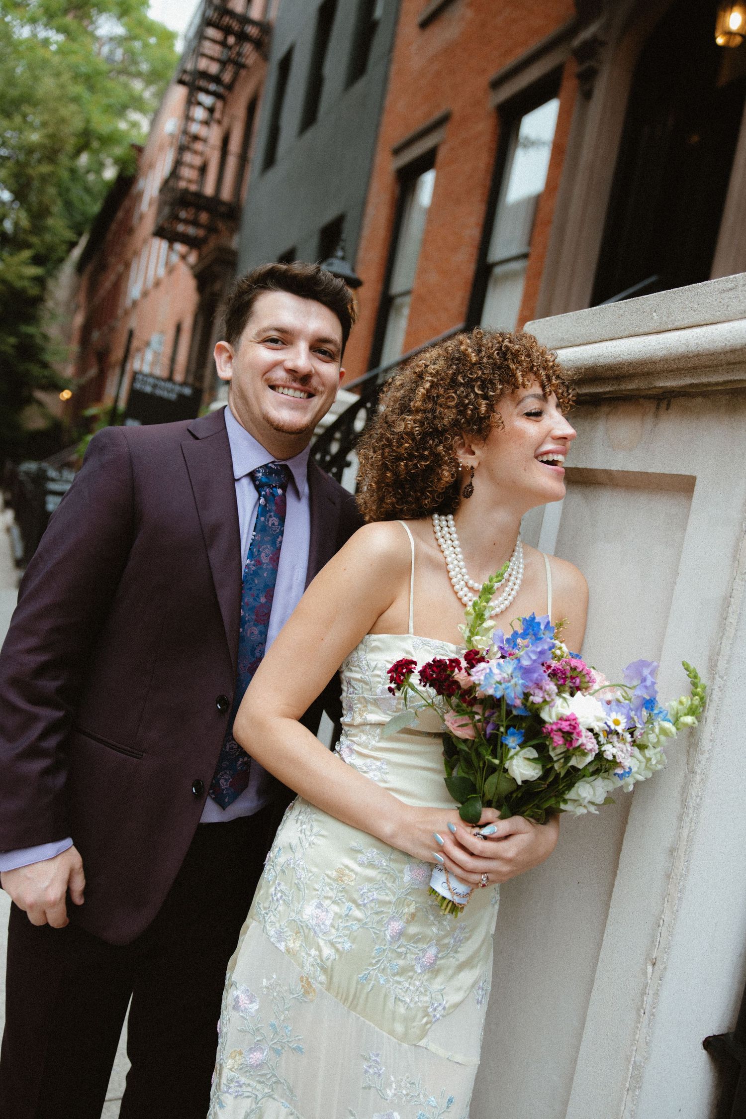 Wedding portraits taken on a charming city street with brick buildings.