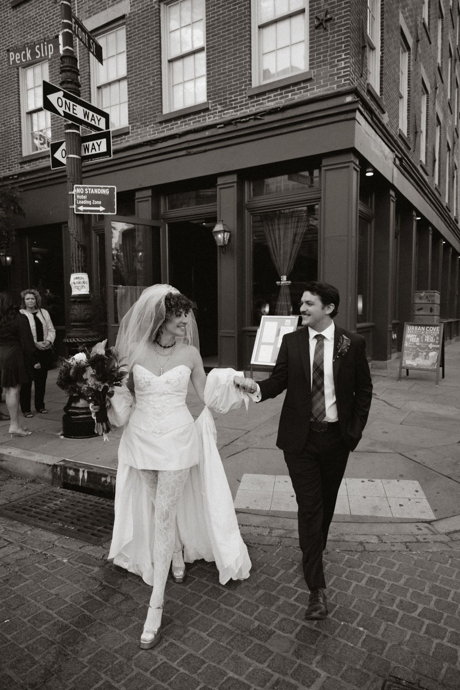 Black and white sequence of couple walking through historic cobblestone streets.