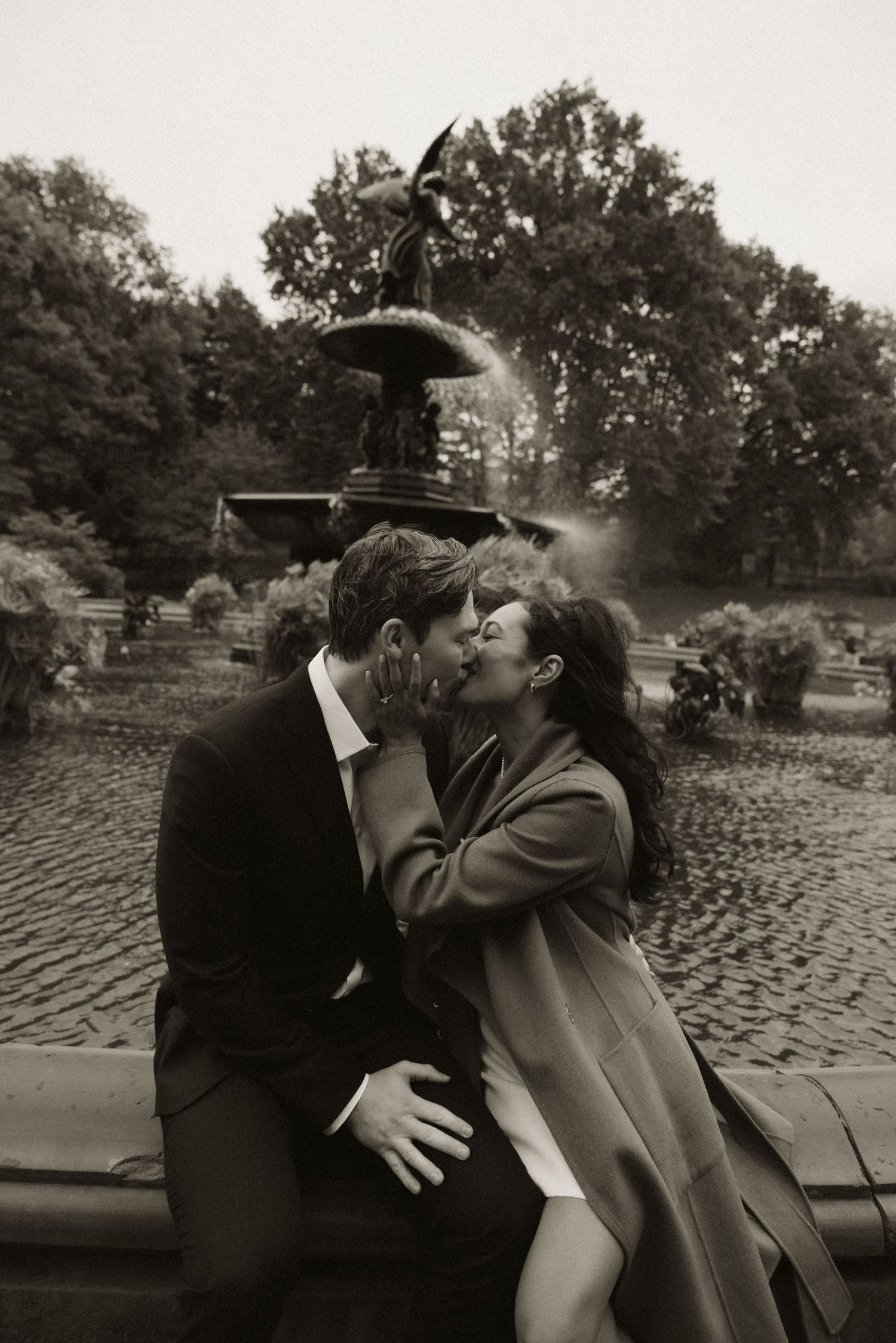 Black and white sequence of couple embracing on cobblestone street.
