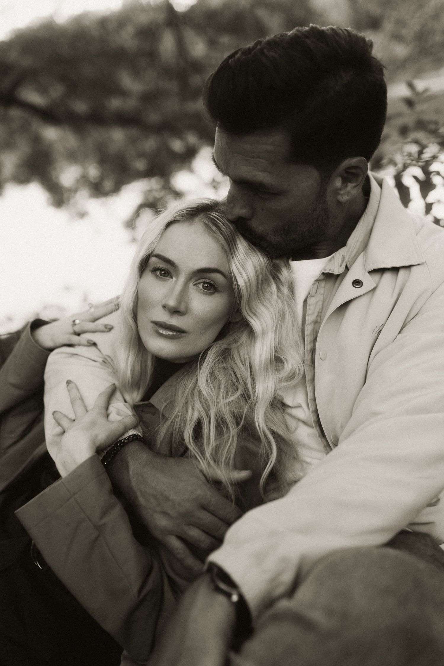 A black and white intimate portrait of a couple sharing a tender moment.