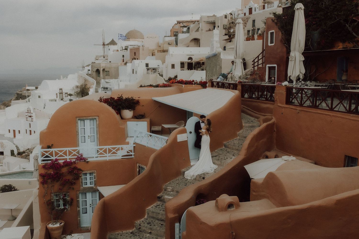 A panoramic view of white buildings and terracotta roofs in Santorini, Greece.